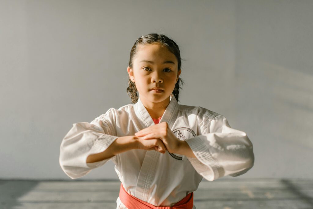 taekwondo à montréal A young girl practicing martial arts in a dobok, exuding focus and determination.