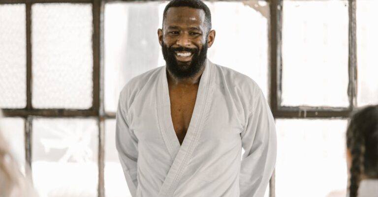 A confident martial arts instructor wearing a black belt in the dojo, exuding positivity.